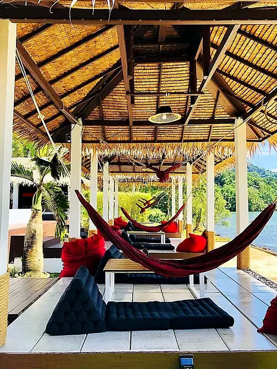 Red hammock inside a thatched cabana